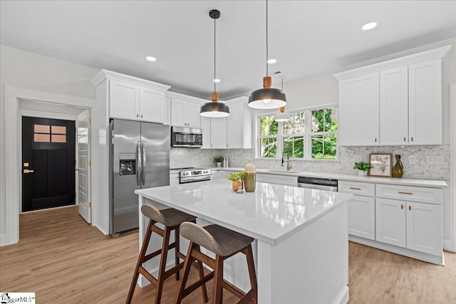 148 Duncan Chapel Rd, Greenville, SC 29617 - kitchen with stainless steel appliances, a sink, light wood-type flooring, light countertops, and backsplash