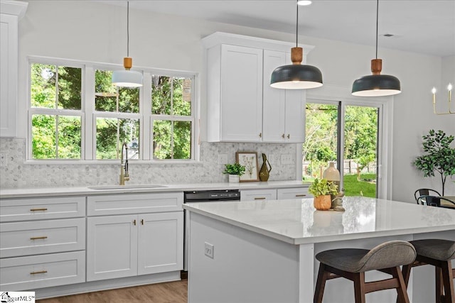 148 Duncan Chapel Rd, Greenville, SC 29617 - kitchen with a sink, backsplash, white cabinets, a kitchen island, and a breakfast bar area