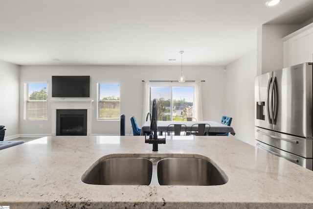 925 Appalachian Dr, Moore, SC 29369 - kitchen featuring stainless steel fridge with ice dispenser, a sink, open floor plan, hanging light fixtures, and a fireplace