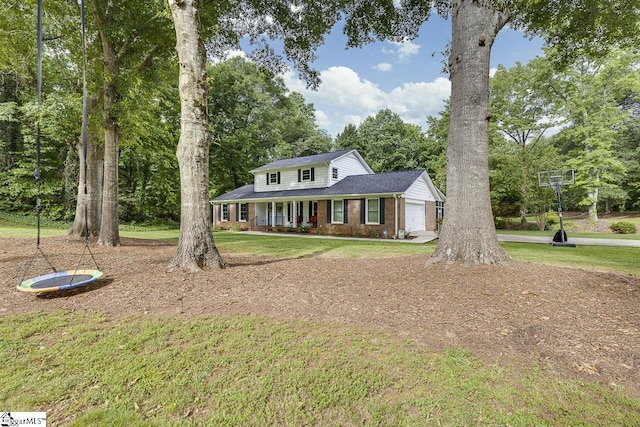 9 Mountain Brook Trl, Greenville, SC 29609 - traditional home with brick siding, covered porch, a garage, a front yard, and view of wooded area