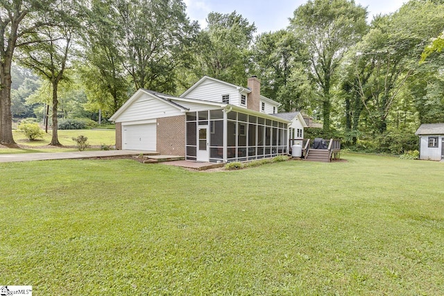 9 Mountain Brook Trl, Greenville, SC 29609 - view of green lawn featuring a sunroom, concrete driveway, a garage, view of scattered trees, and a wooden deck