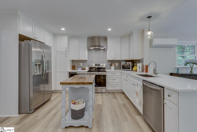 9 Mountain Brook Trl, Greenville, SC 29609 - kitchen featuring appliances with stainless steel finishes, wall chimney range hood, a sink, a wall mounted AC, and a peninsula