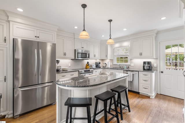 109 Appomattox Dr, Simpsonville, SC 29681 - kitchen featuring stainless steel appliances, dark stone countertops, ornamental molding, a kitchen bar, and light wood-style floors