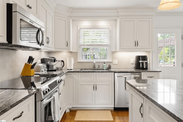 109 Appomattox Dr, Simpsonville, SC 29681 - kitchen featuring appliances with stainless steel finishes, light wood-style floors, white cabinets, tasteful backsplash, and ornamental molding