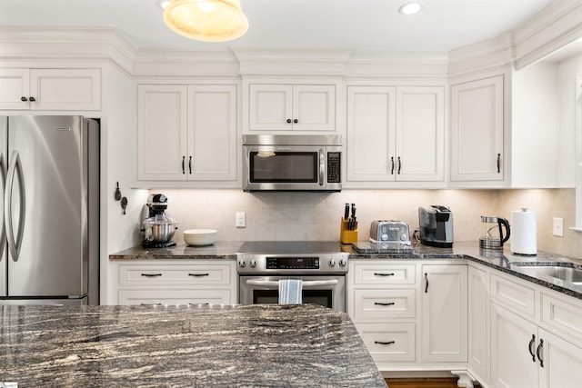 109 Appomattox Dr, Simpsonville, SC 29681 - kitchen with stainless steel appliances, white cabinetry, dark stone counters, backsplash, and crown molding