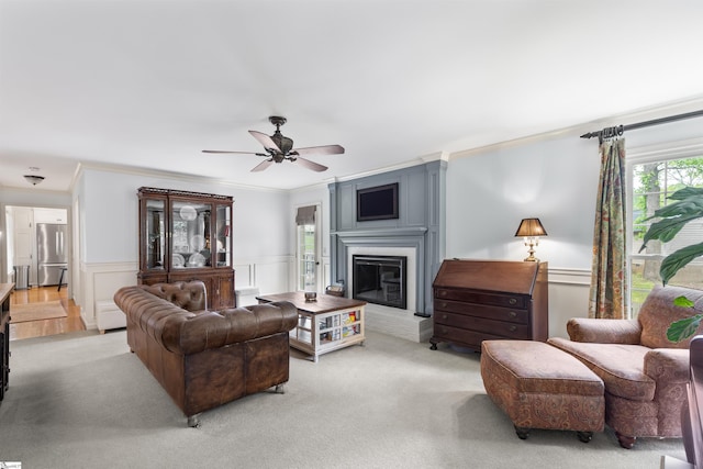 109 Appomattox Dr, Simpsonville, SC 29681 - living room featuring ornamental molding, light colored carpet, ceiling fan, a glass covered fireplace, and wainscoting