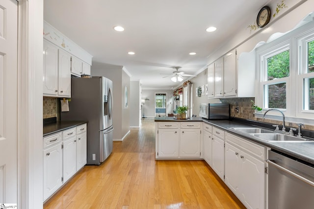 101 Long View Ln, Pickens, SC 29671 - kitchen featuring stainless steel appliances, a sink, a peninsula, dark countertops, and white cabinetry