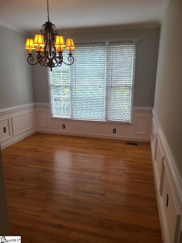 424 Grand Oak Way, Moore, SC 29369 - unfurnished dining area with a chandelier, a decorative wall, ornamental molding, wood finished floors, and wainscoting