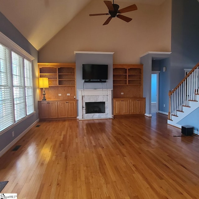 424 Grand Oak Way, Moore, SC 29369 - unfurnished living room with high vaulted ceiling, a ceiling fan, a high end fireplace, stairway, and light wood-style flooring