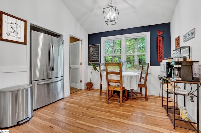 405 Wilson Bridge Rd, Simpsonville, SC 29680 - dining area featuring light wood-type flooring, vaulted ceiling, a chandelier, and wainscoting