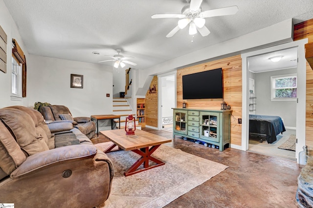405 Wilson Bridge Rd, Simpsonville, SC 29680 - living area with stairs, a ceiling fan, wooden walls, a textured ceiling, and concrete floors