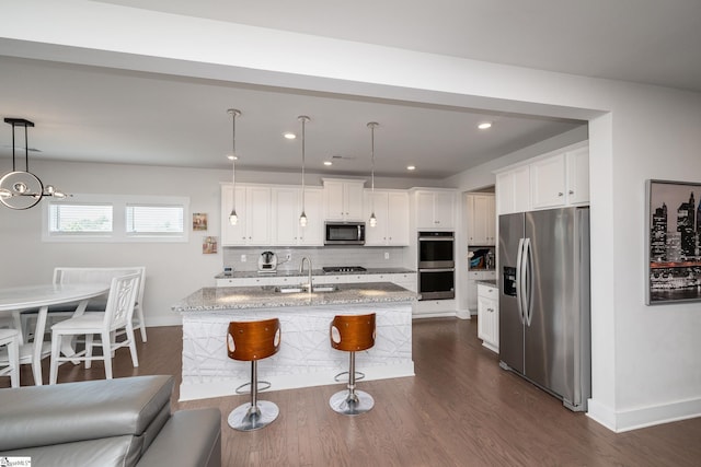116 Quiet Creek Ct, Simpsonville, SC 29681 - kitchen with appliances with stainless steel finishes, a sink, backsplash, a kitchen bar, and light stone countertops