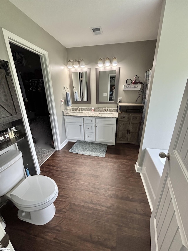 844 Brennan Way, Lyman, SC 29365 - bathroom featuring toilet, double vanity, wood finished floors, a spacious closet, and baseboards