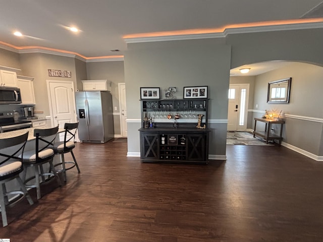 844 Brennan Way, Lyman, SC 29365 - kitchen featuring appliances with stainless steel finishes, arched walkways, crown molding, white cabinetry, and dark wood-style flooring