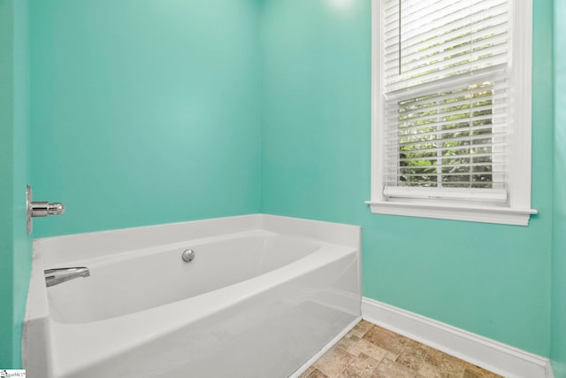 1847 Bertha Knight Rd, Lancaster, SC 29720 - full bathroom featuring a garden tub, baseboards, and stone finish floors
