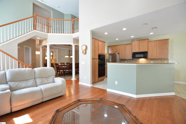 10 Bamburgh Brae Ct, Simpsonville, SC 29681 - living area with ornate columns, light wood-type flooring, recessed lighting, a high ceiling, and stairs