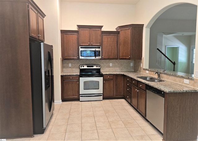 605 Spirit Mountain Ln, Easley, SC 29642 - kitchen featuring stainless steel appliances, a sink, tasteful backsplash, arched walkways, and light tile patterned floors