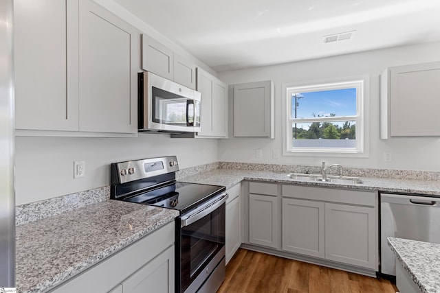 474 Grantham Ct, Spartanburg, SC 29303 - kitchen featuring stainless steel appliances, a sink, wood finished floors, and light stone countertops