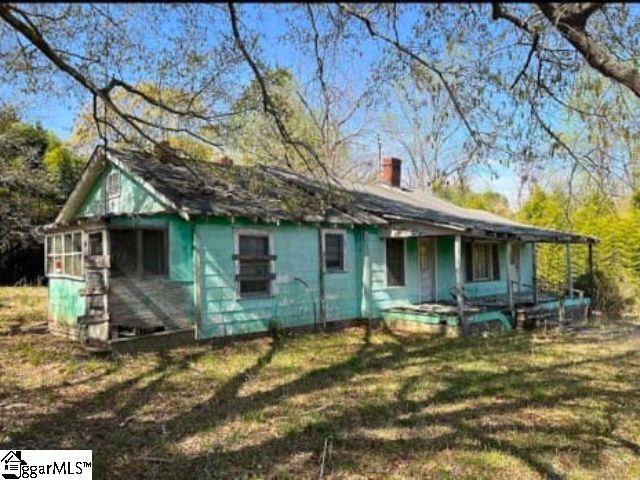 130 Poplar St, Pacolet, SC 29372 - view of front of home featuring covered porch, a chimney, and a front yard