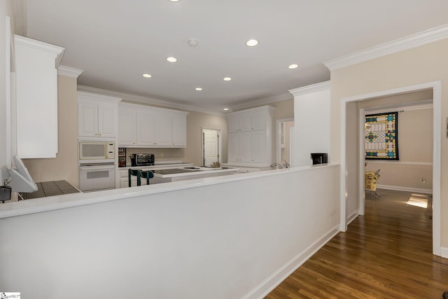 1004 Neely Farm Dr, Simpsonville, SC 29680 - kitchen with white appliances, recessed lighting, ornamental molding, a peninsula, and white cabinetry