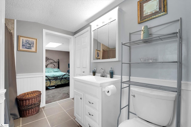 2100 Marchbanks Ave, Anderson, SC 29621 - ensuite bathroom with vanity, wainscoting, a textured ceiling, toilet, and tile patterned floors