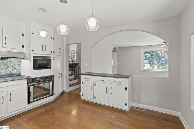 106 Chesterfield Rd, Greenville, SC 29605 - kitchen featuring black appliances, arched walkways, dark countertops, decorative backsplash, and dark wood-style floors