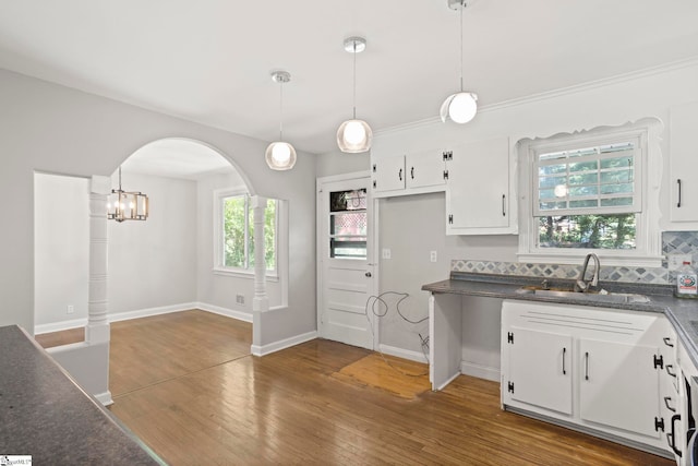 106 Chesterfield Rd, Greenville, SC 29605 - kitchen with a sink, dark countertops, white cabinets, wood finished floors, and arched walkways