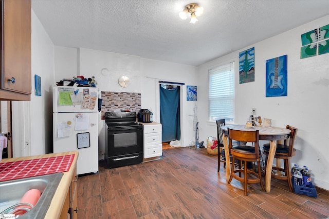 127 Orr St, Piedmont, SC 29673 - kitchen with freestanding refrigerator, black range with electric stovetop, dark wood finished floors, a textured ceiling, and a sink