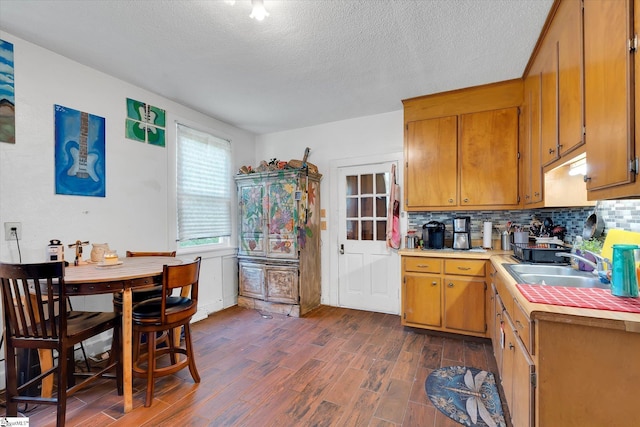127 Orr St, Piedmont, SC 29673 - kitchen featuring a sink, light countertops, dark wood-type flooring, decorative backsplash, and brown cabinets