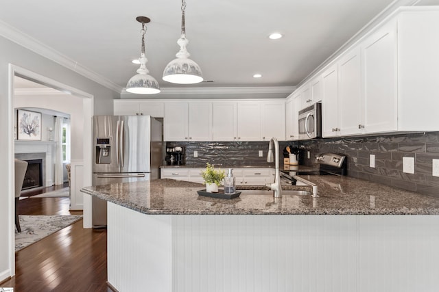 435 Grayson Dr, Moore, SC 29369 - kitchen with stainless steel appliances, crown molding, a peninsula, dark stone counters, and white cabinetry