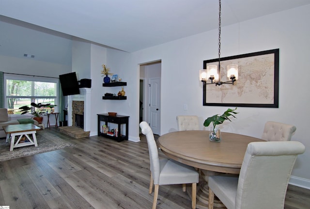 1608 Rock Springs Rd, Lavonia, GA 30553 - dining area featuring a chandelier, wood finished floors, a fireplace, and baseboards