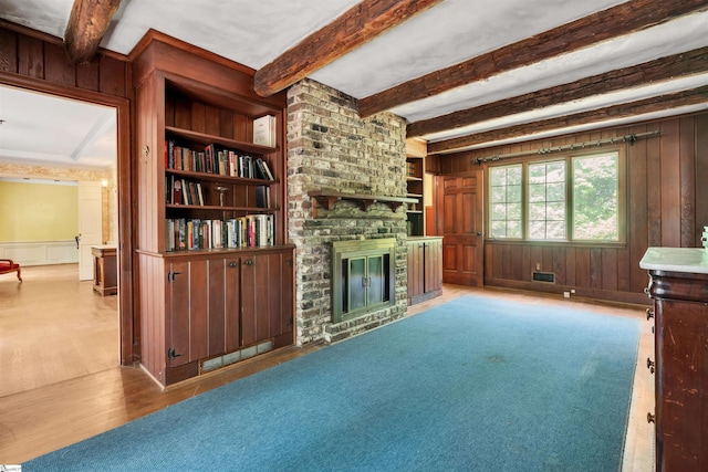 141 Shoreham Rd, Spartanburg, SC 29307 - unfurnished living room with a fireplace, beam ceiling, wood finished floors, wooden walls, and built in shelves