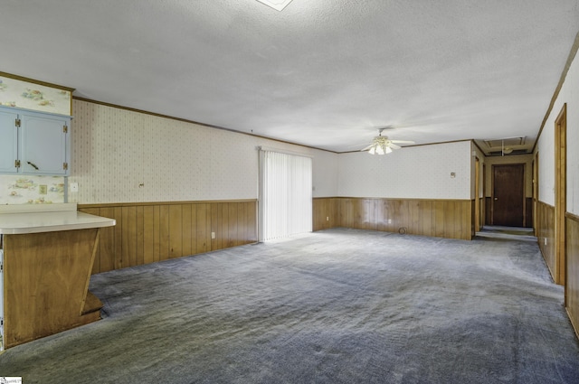 367 Janulis St, Spartanburg, SC 29301 - unfurnished living room with wainscoting, a textured ceiling, ceiling fan, carpet flooring, and wallpapered walls