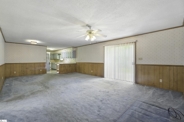 367 Janulis St, Spartanburg, SC 29301 - empty room featuring wainscoting, wood walls, wallpapered walls, a ceiling fan, and light colored carpet