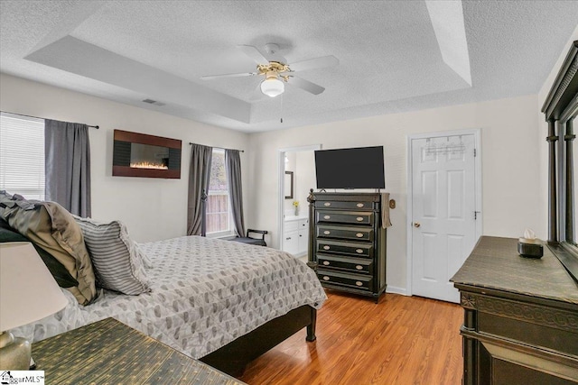 104 Pin Oak Dr, Greenwood, SC 29649 - bedroom with a textured ceiling, light wood-style floors, a tray ceiling, and a ceiling fan