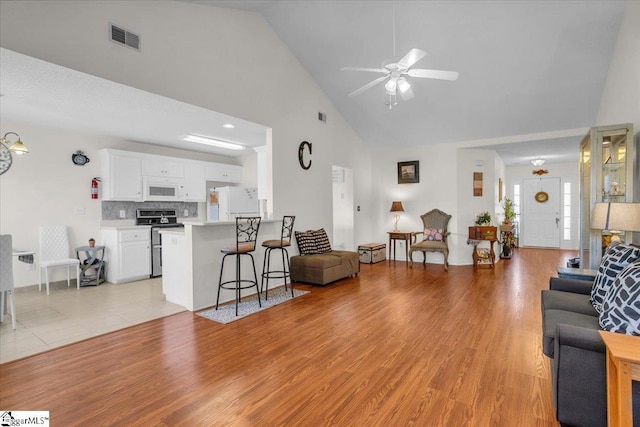 104 Pin Oak Dr, Greenwood, SC 29649 - living area with high vaulted ceiling, a ceiling fan, light wood-style floors, and baseboards