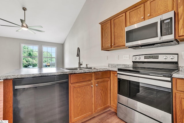 114 Tamelia Ct, Greer, SC 29650 - kitchen with appliances with stainless steel finishes, a sink, a peninsula, light wood finished floors, and lofted ceiling