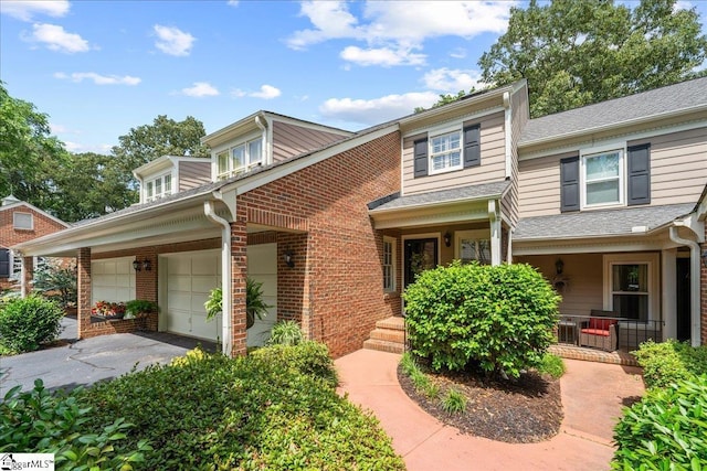 1250 Shadow Way, Greenville, SC 29615 - view of front of property with driveway, brick siding, an attached garage, covered porch, and a shingled roof