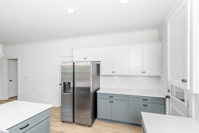 101 Duke St, Greenville, SC 29609 - kitchen featuring stainless steel fridge with ice dispenser, ornamental molding, light countertops, white cabinets, and light wood-style floors