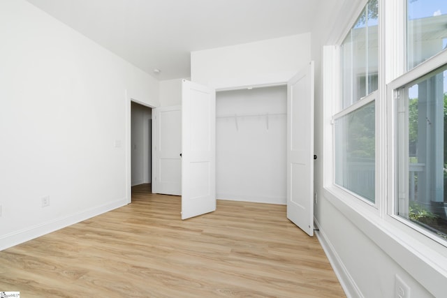 101 Duke St, Greenville, SC 29609 - unfurnished bedroom featuring multiple windows, light wood finished floors, baseboards, and a closet