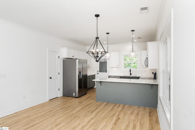 101 Duke St, Greenville, SC 29609 - kitchen with stainless steel fridge, a chandelier, a peninsula, crown molding, and white cabinets