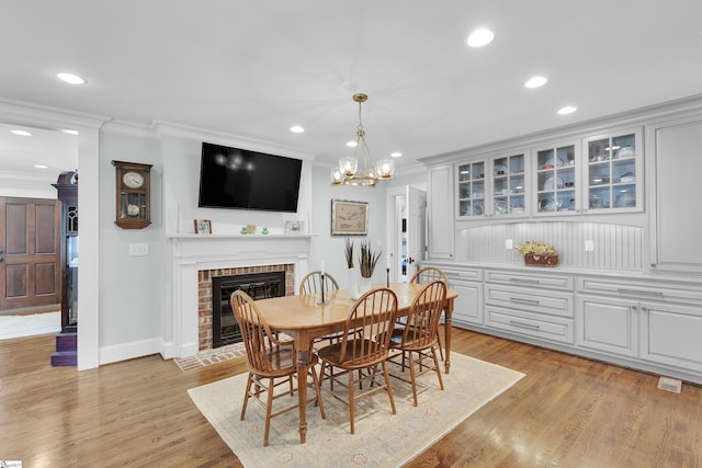 15 High Hill St, Greenville, SC 29605 - dining room featuring crown molding, a fireplace, recessed lighting, light wood-style floors, and a chandelier