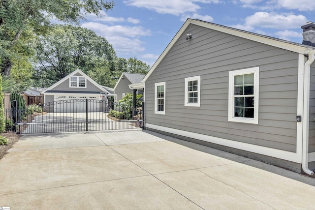 15 High Hill St, Greenville, SC 29605 - view of home's exterior with an outdoor structure, a garage, a chimney, and concrete driveway