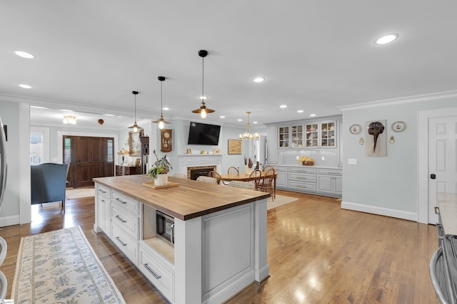 15 High Hill St, Greenville, SC 29605 - kitchen featuring wood counters, ornamental molding, white cabinets, a center island, and decorative light fixtures