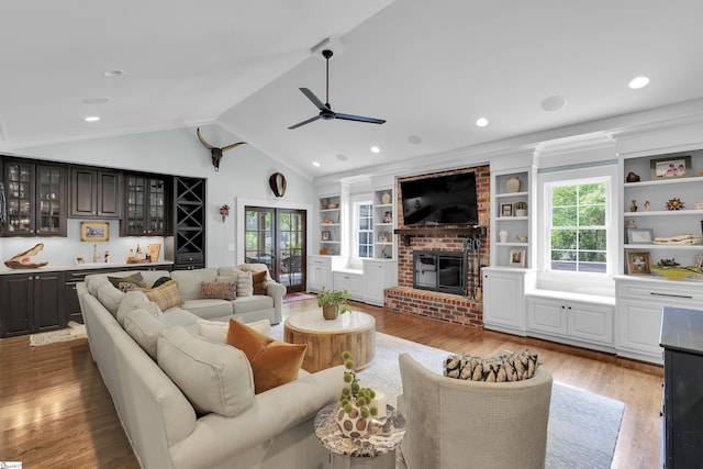 15 High Hill St, Greenville, SC 29605 - living area featuring a ceiling fan, wood finished floors, bar with sink, a brick fireplace, and vaulted ceiling