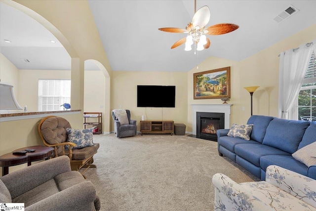 101 Roberts Hill Dr, Taylors, SC 29687 - carpeted living room with lofted ceiling, arched walkways, a ceiling fan, and a fireplace with flush hearth