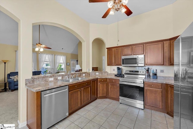 101 Roberts Hill Dr, Taylors, SC 29687 - kitchen with appliances with stainless steel finishes, ceiling fan, a sink, brown cabinets, and high vaulted ceiling
