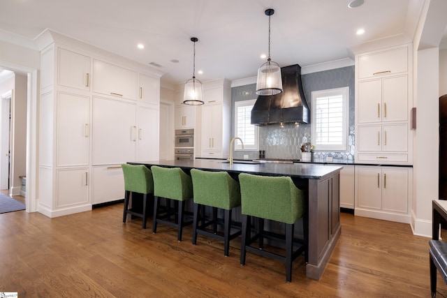 36 Southland Ave, Greenville, SC 29601 - kitchen with premium range hood, dark countertops, a kitchen bar, white cabinetry, and ornamental molding