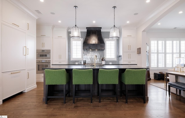36 Southland Ave, Greenville, SC 29601 - kitchen featuring custom exhaust hood, a sink, dark countertops, a kitchen island with sink, and a kitchen bar