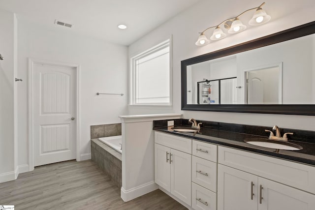 381 Butler Rd, Lyman, SC 29365 - full bathroom featuring double vanity, a garden tub, wood finished floors, and baseboards